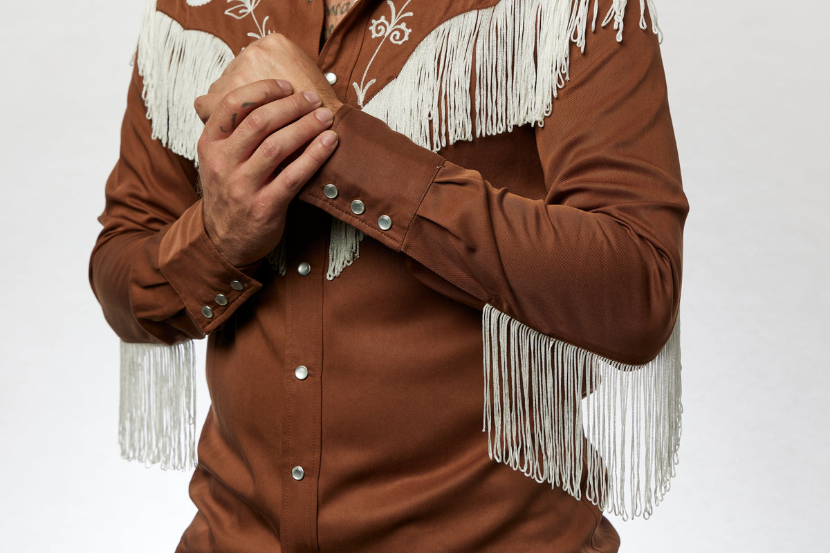 Close-up of the H Bar C Taos brown shirt with white fringe and pearl snaps.