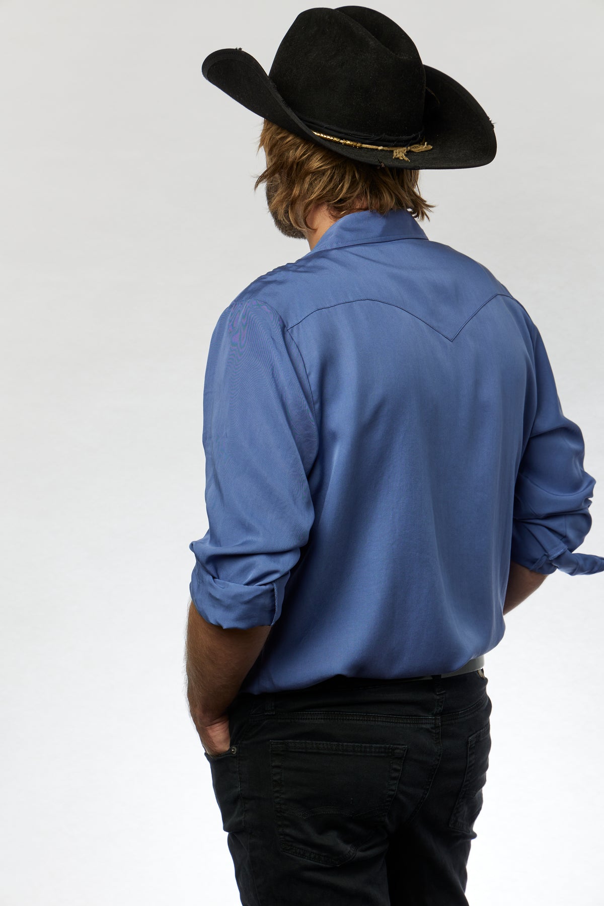 Back view of the H Bar C Denver periwinkle western shirt worn with black jeans and a black hat.