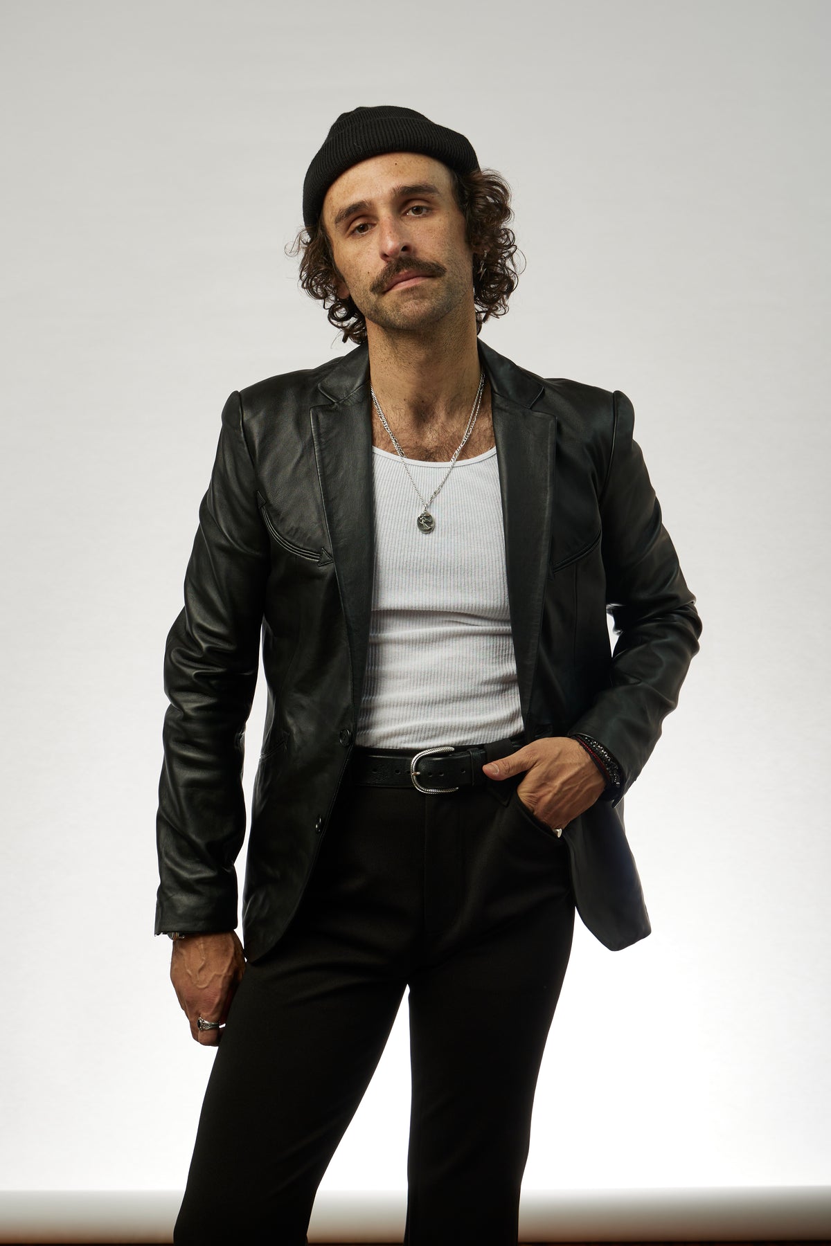 Man wearing the H Bar C Carson black lambskin jacket with a white tank and black pants.