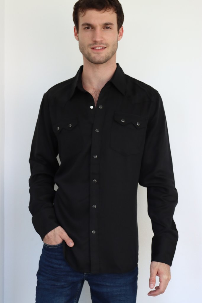 Man wearing the H Bar C Kansas City black western shirt with sawtooth pockets and pearl snaps, with jeans.