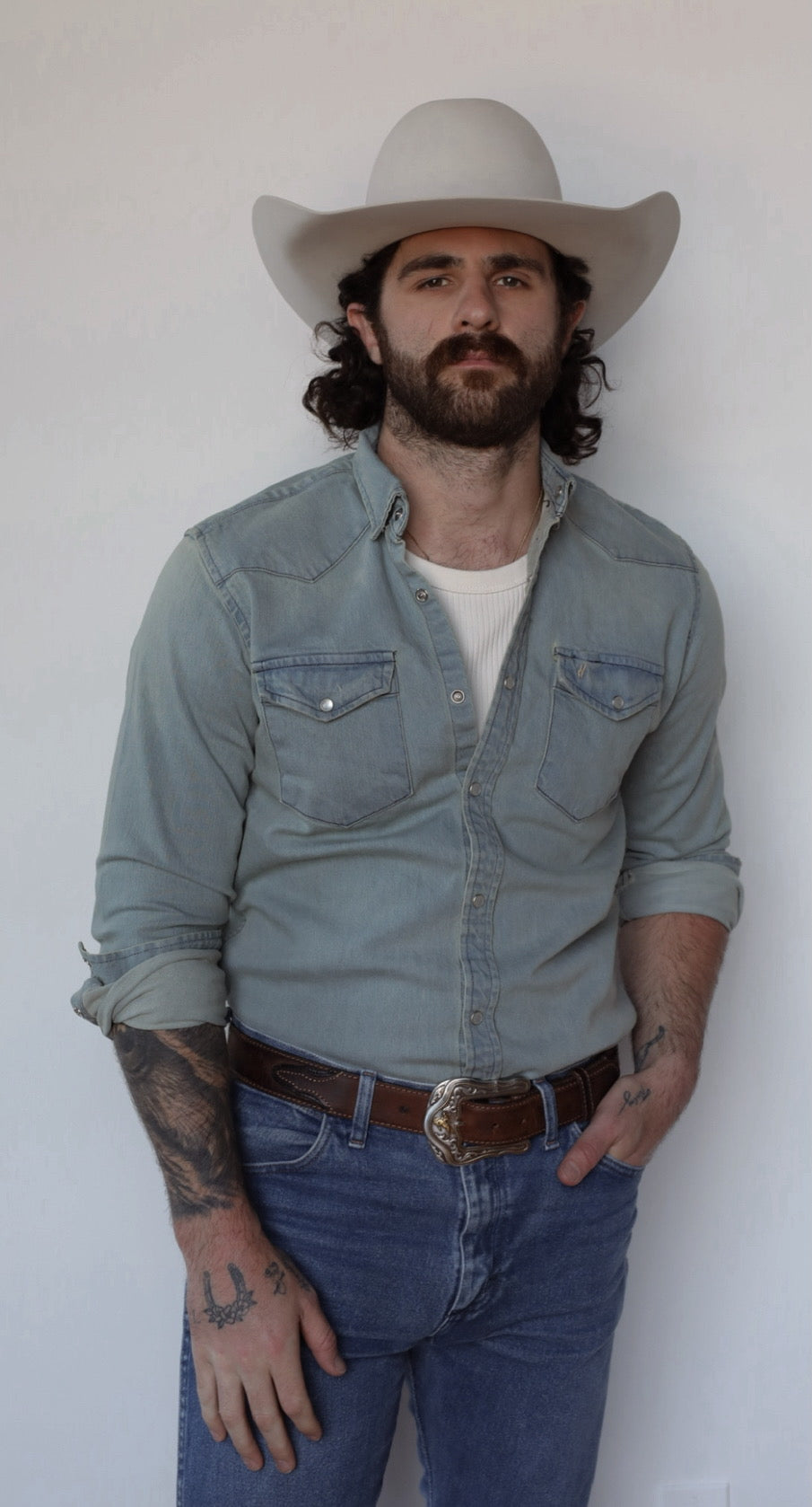 Front view of the H Bar C Resurgent men's snap shirt with rolled sleeves, worn with jeans and a cowboy hat.