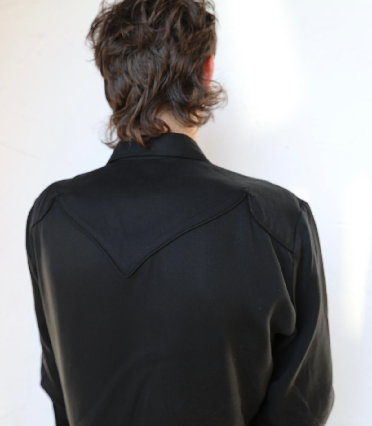 Back view of the H Bar C Reno black on black shirt showing the piped western back yoke.