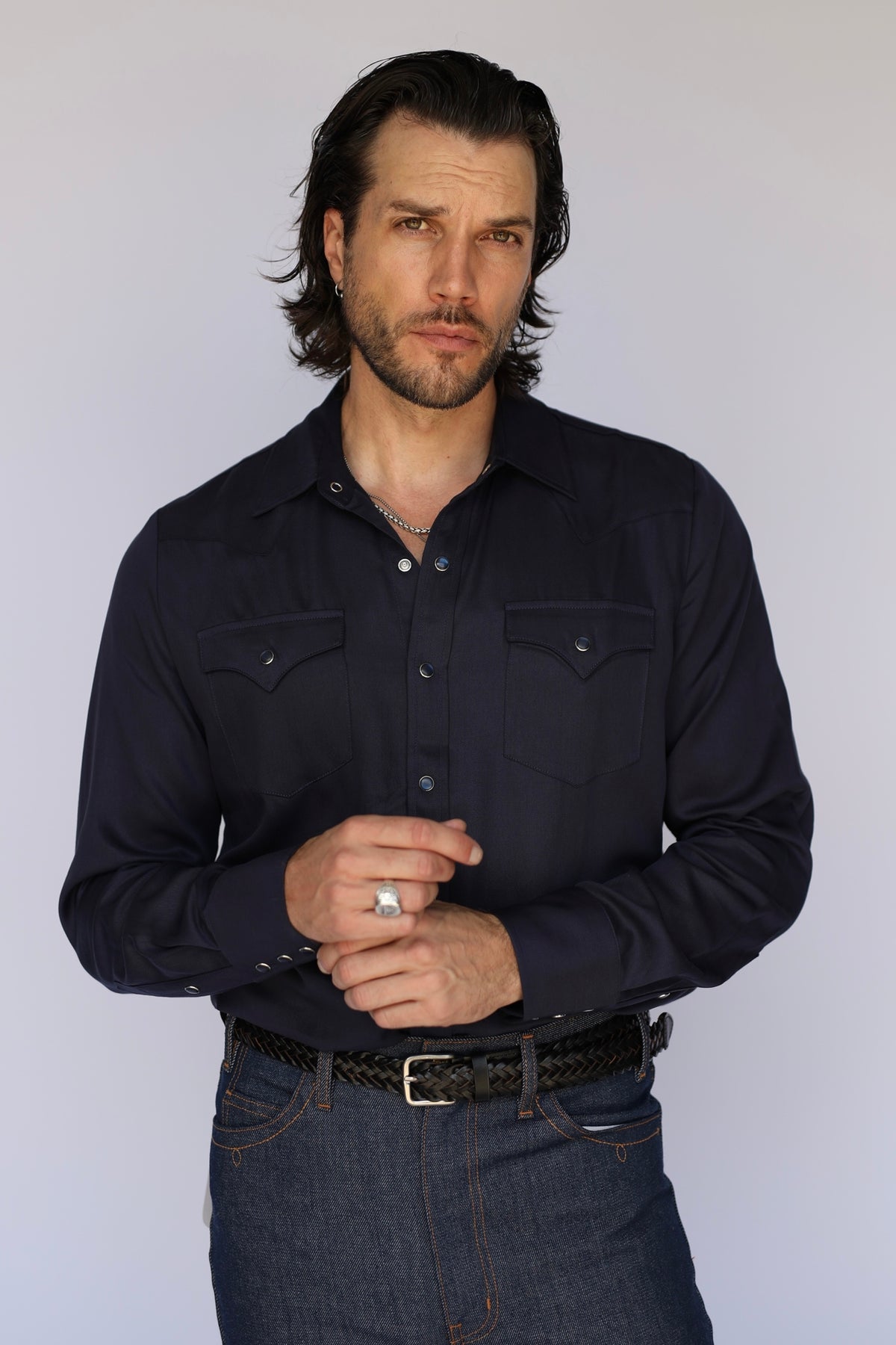 Man wearing the H Bar C Denver men's shirt in navy, a classic Tencel pearl snap western shirt made since 1938, with dark jeans.
