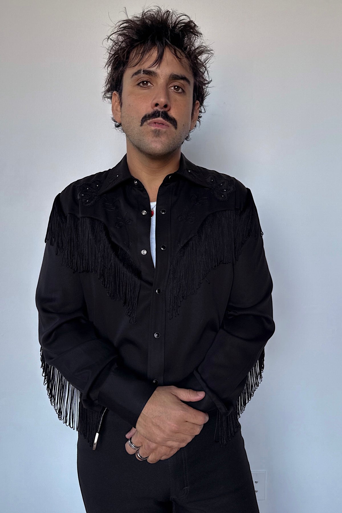 Man wearing the H Bar C Taos men's shirt in all black with black fringe on the yokes and sleeves.