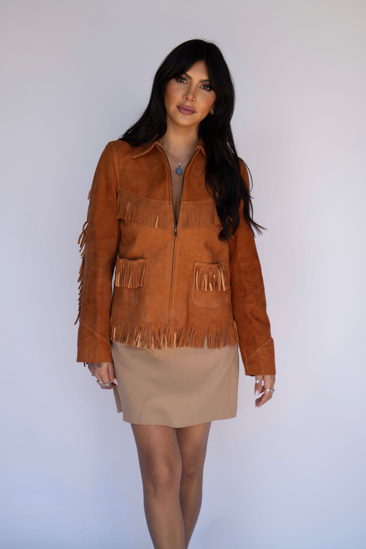 H Bar C Omaha women's brown suede fringe jacket styled with a beige mini skirt.