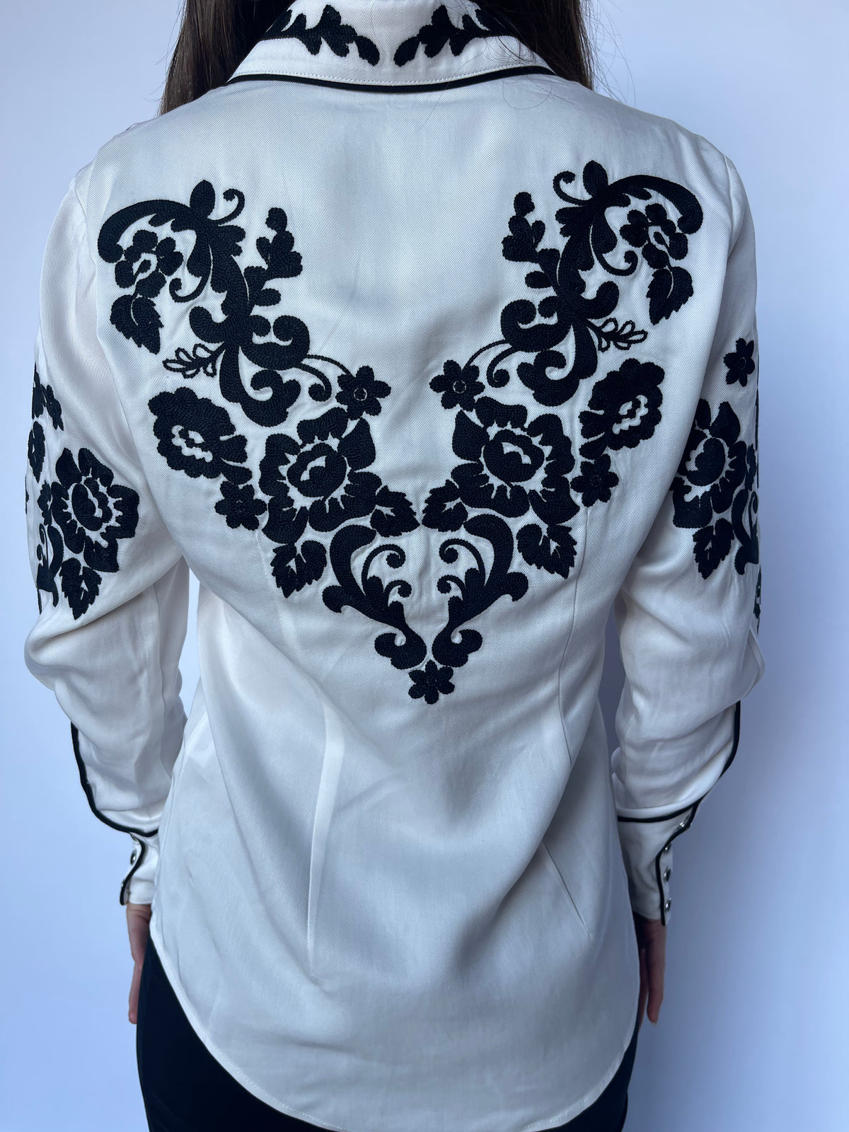 Close-up of the black chain stitched rose embroidery across the back of the H Bar C Fort Worth white shirt.