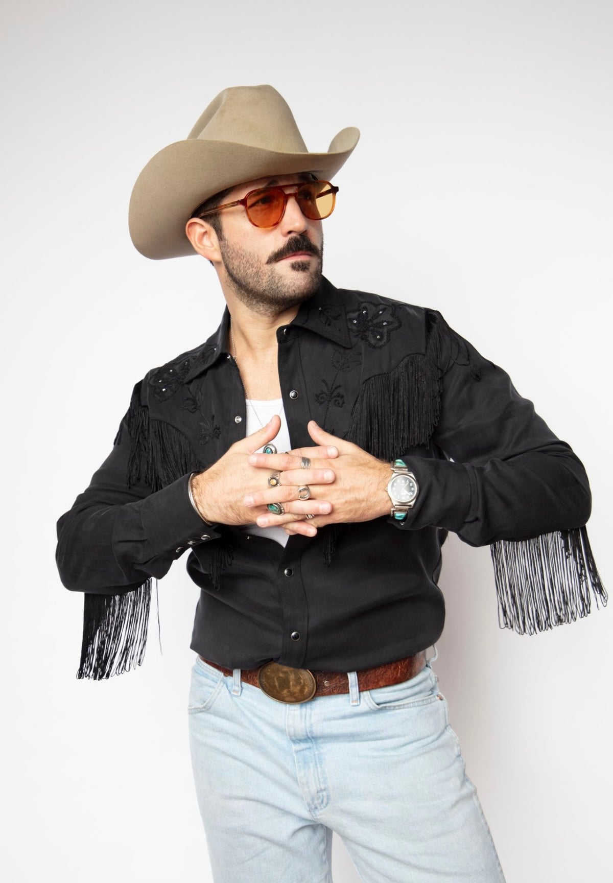 Man snapping the cuff of the H Bar C Taos black fringe western shirt with a cowboy hat.