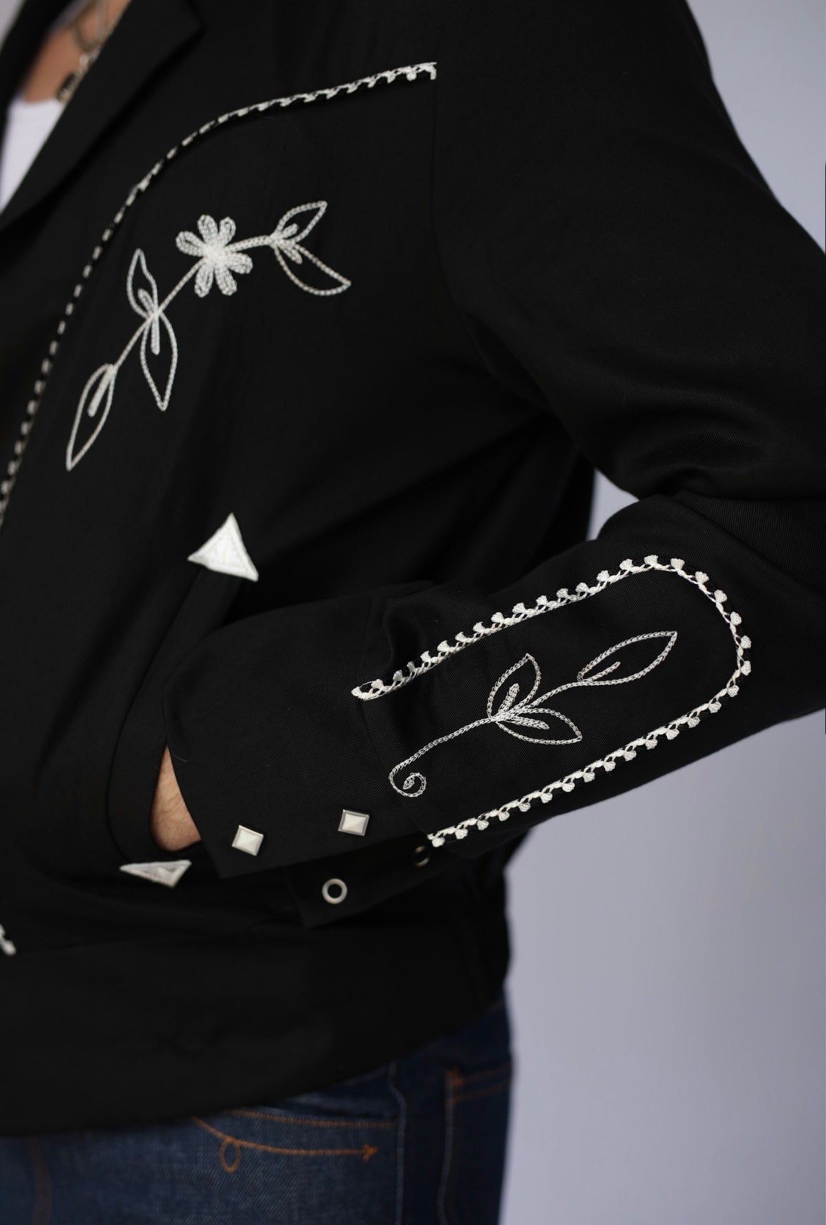 Pocket and arrow detail of the H Bar C Bolero Nogales jacket with white floral embroidery.
