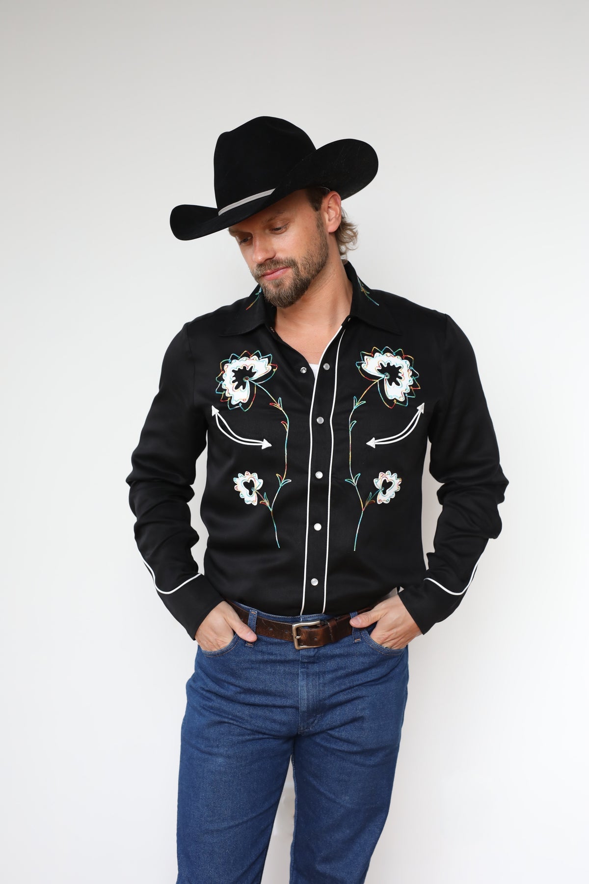 Front view of the H Bar C Texas black embroidered western shirt with jeans and a black hat.