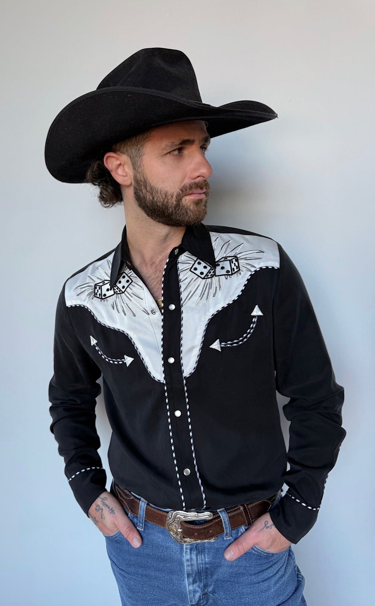 Three-quarter view of the H Bar C Jillette black shirt with white floral yokes and a black hat.