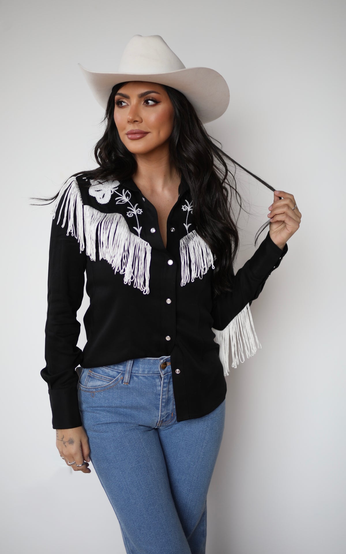Model in the H Bar C Taos black and white fringe women's western shirt with jeans and cowboy hat.