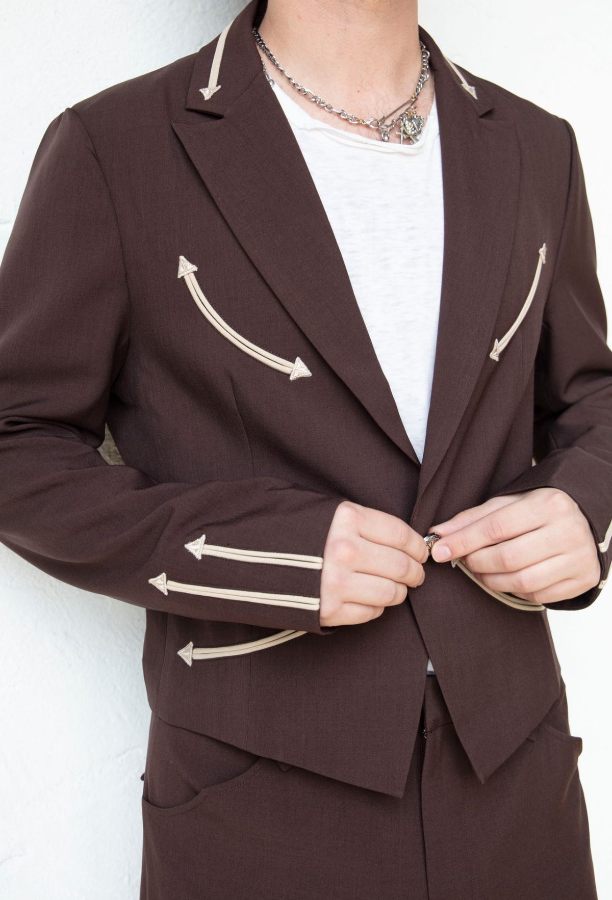 Front close-up of the H Bar C Calamity chocolate jacket with cream arrow pockets and lapel details.