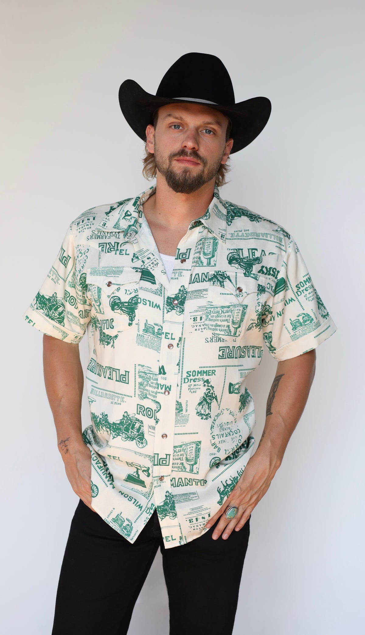 H Bar C Newport Somerville short sleeve shirt with hands in pockets and a black cowboy hat.
