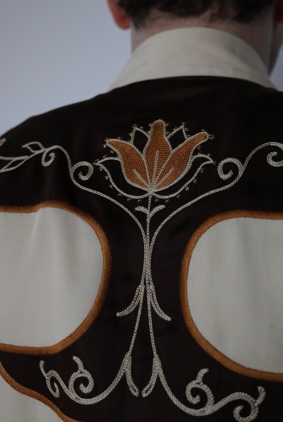 Back yoke detail of the H Bar C Santa Barbara shirt with embroidered tulip motif on brown.