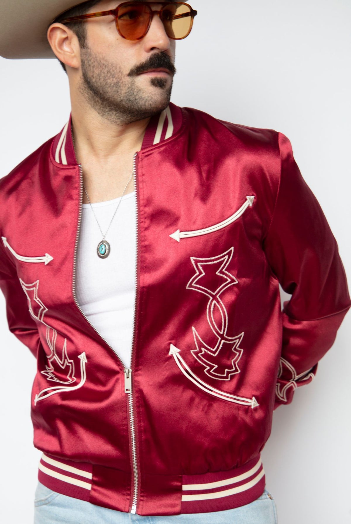 Close-up of a man in the H Bar C Odessa red satin tour jacket designed by Jess Carson.