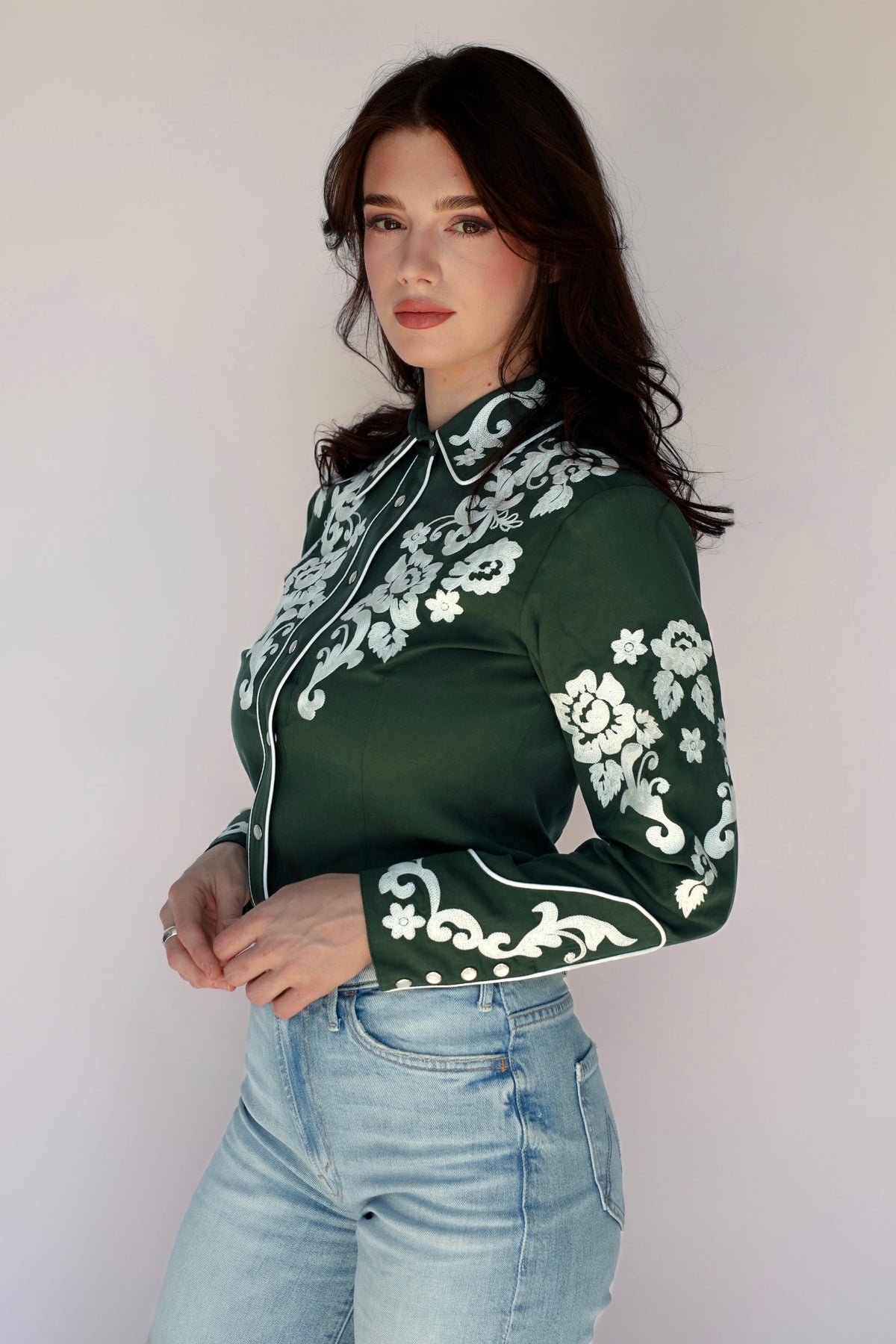 Three-quarter view of the H Bar C Fort Worth women's green western shirt tucked into jeans.