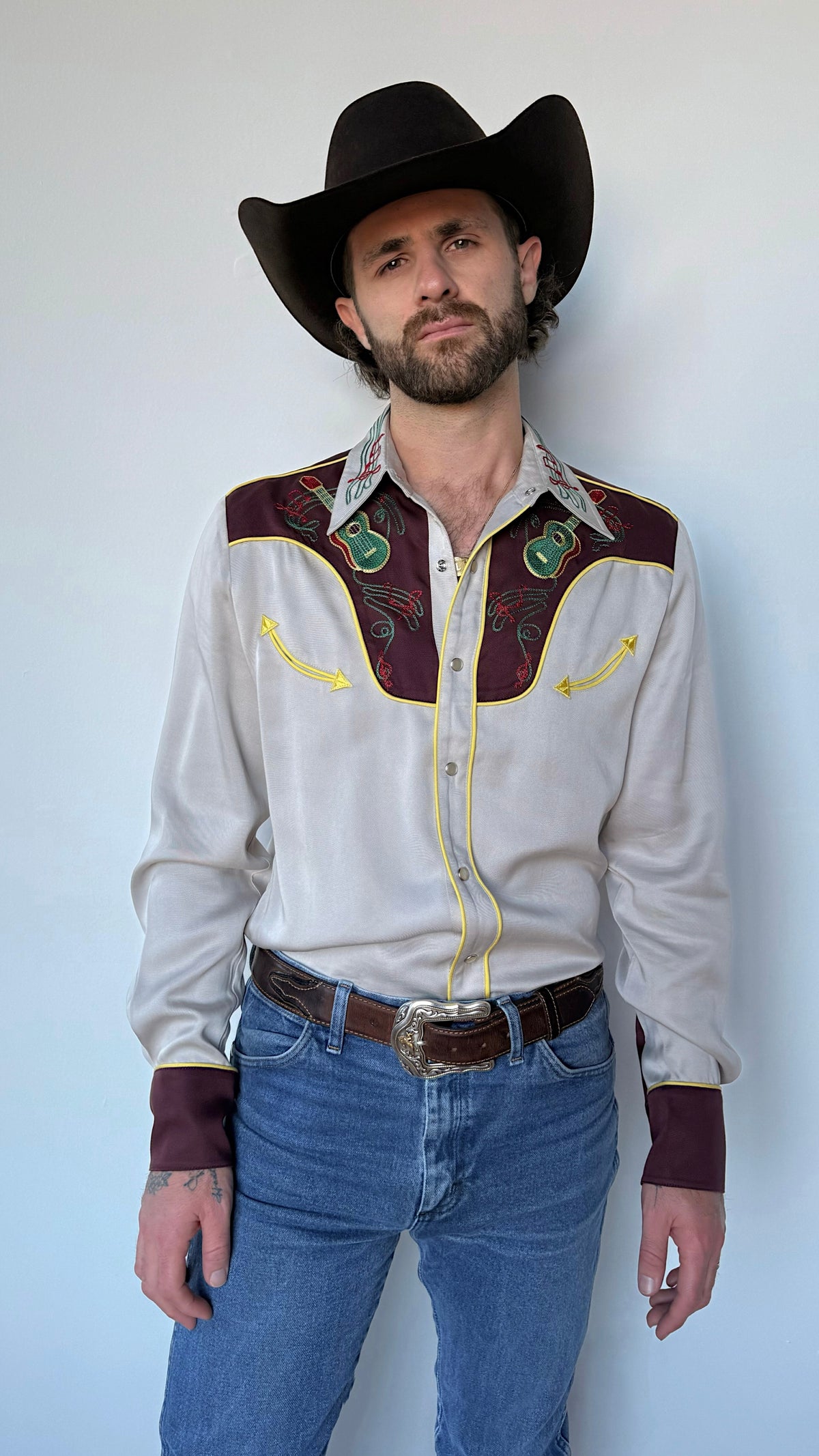 Front view of the H Bar C Cowboy Bob cream and maroon western shirt with jeans and black hat.
