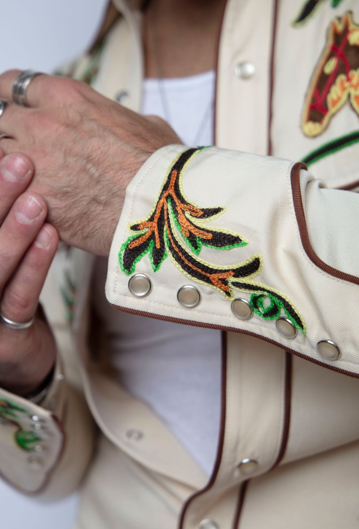 Close-up of the embroidered floral cuff and pearl snaps on the H Bar C Calabasas off-white western shirt.