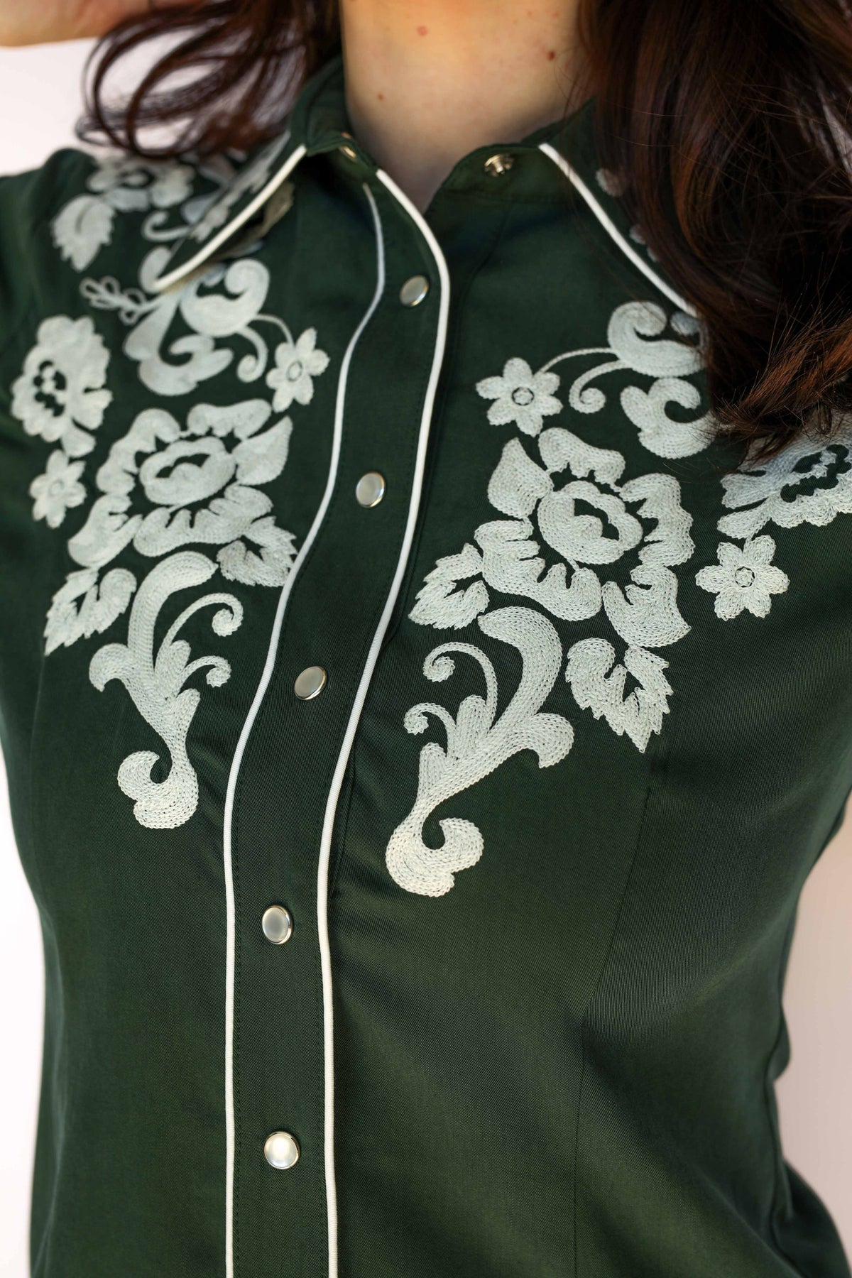 Close-up of the white floral embroidery and piped placket on the H Bar C Fort Worth green shirt.