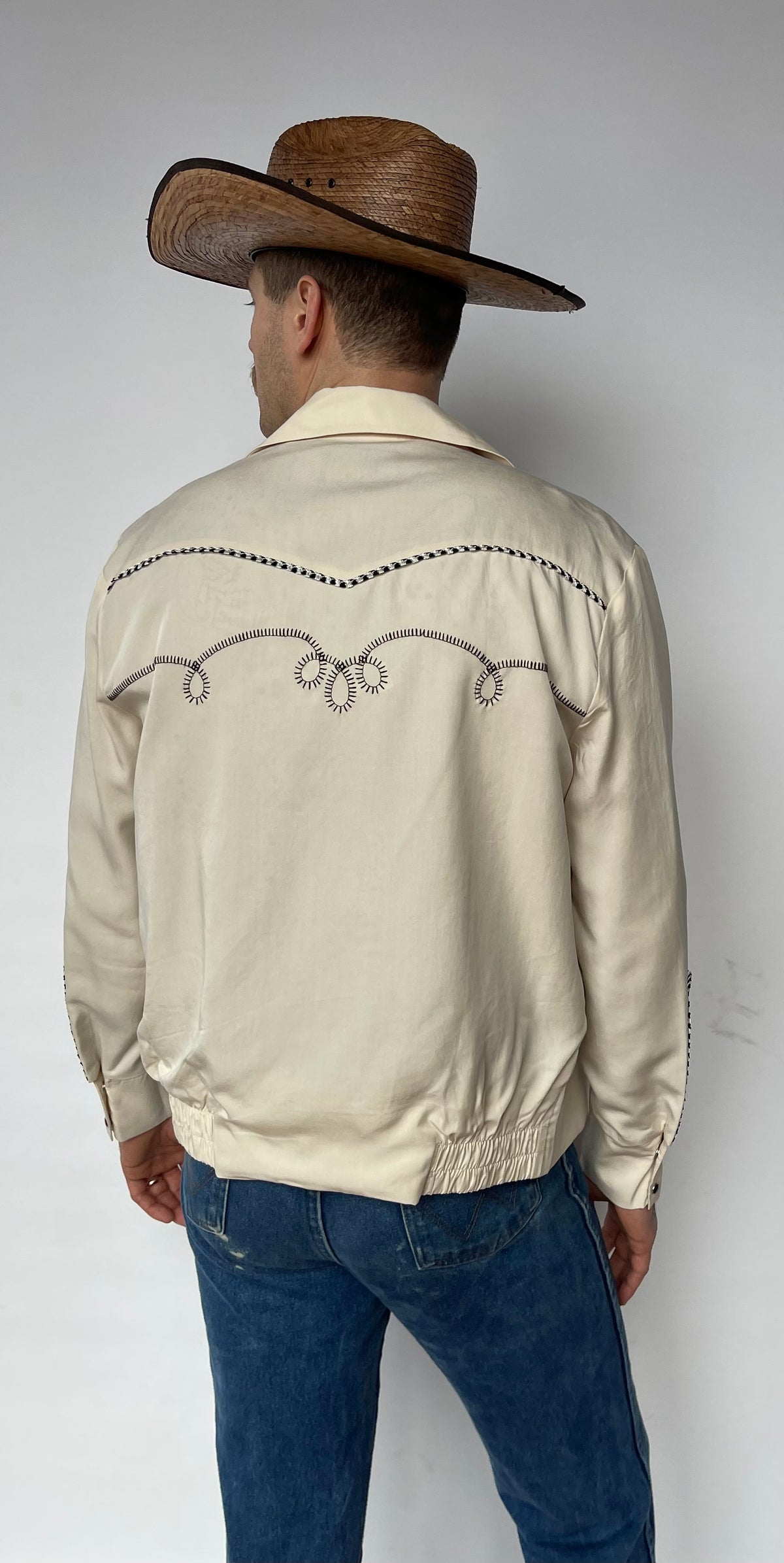 Back view of the H Bar C Bolero off-white jacket with brown embroidered back yoke.