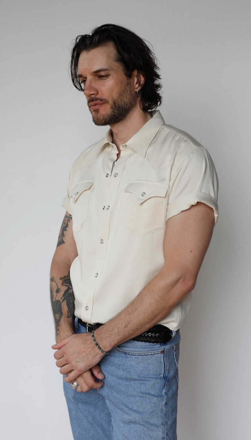 Three-quarter view of the H Bar C Newport off white short sleeve western shirt worn with light wash jeans.
