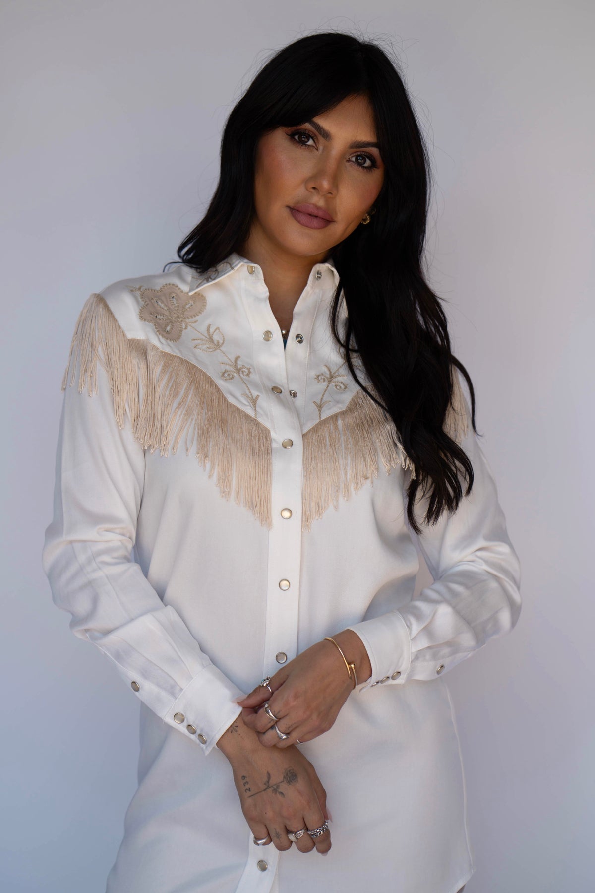Close-up of the H Bar C Roswell white shirt dress with beige fringe and embroidery on the yoke.