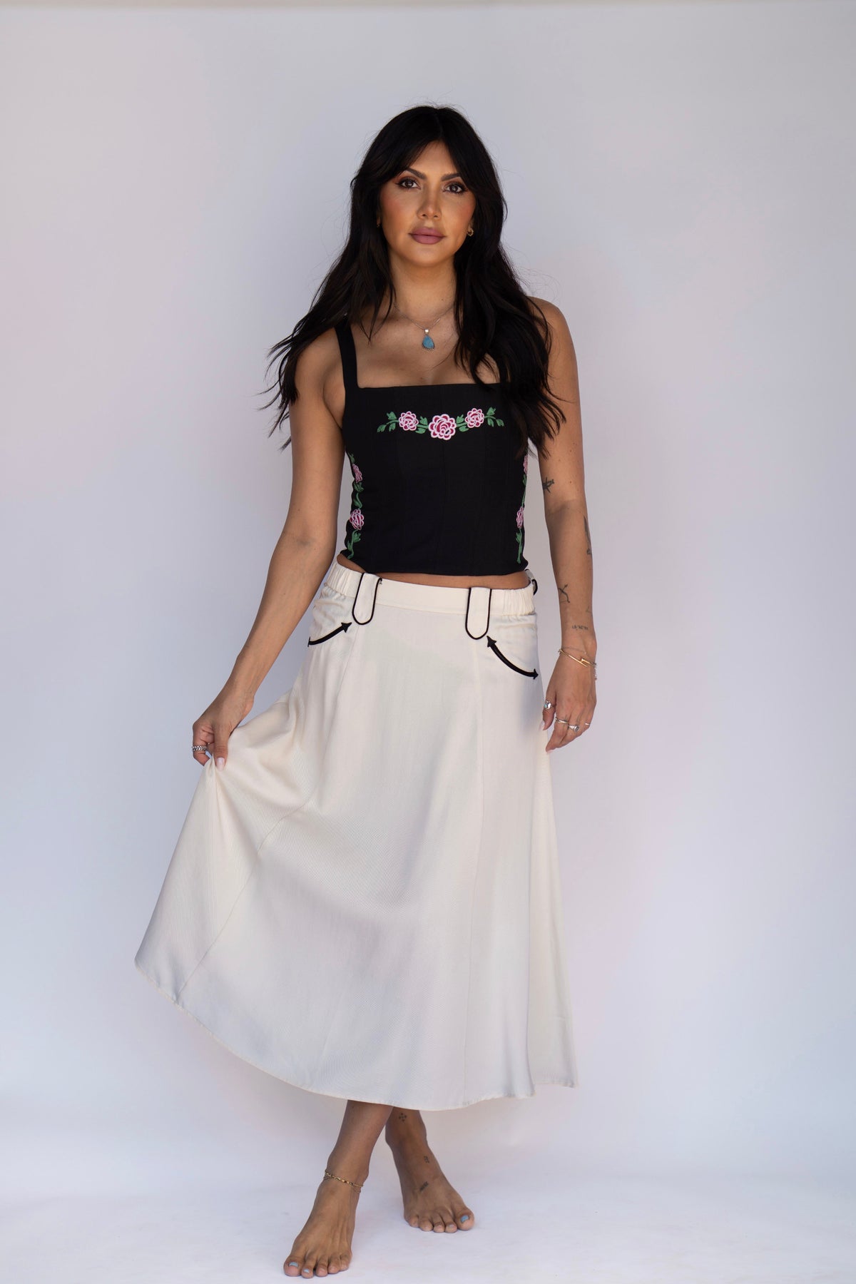 Model in the H Bar C Santa Fe off white skirt with black piping and a black corset top.