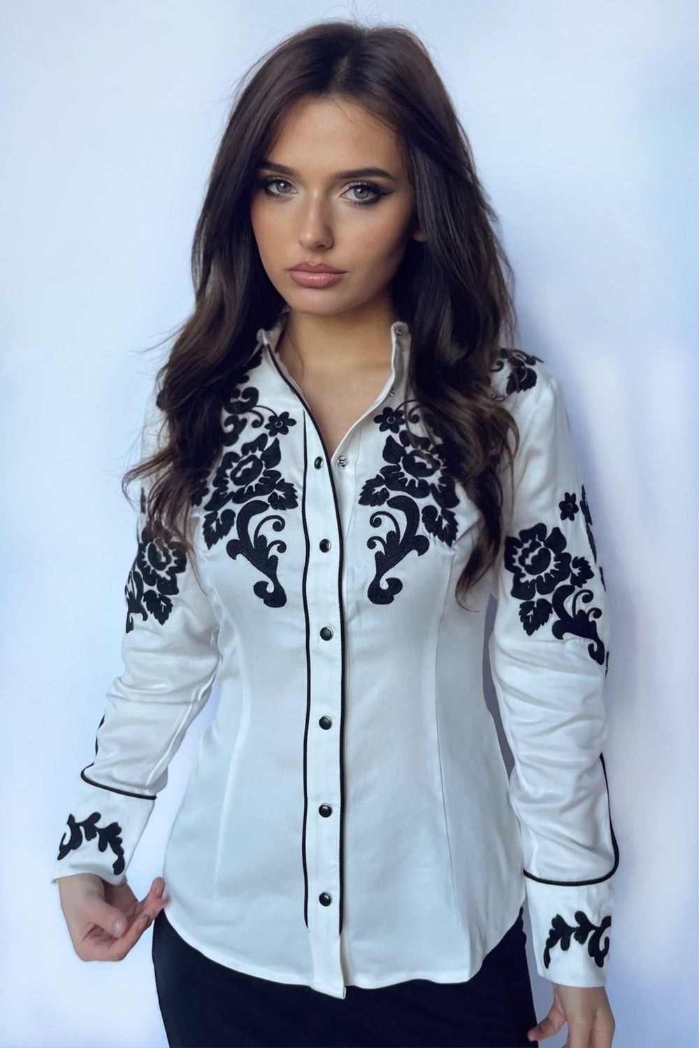 Woman wearing the H Bar C Fort Worth women's shirt in white with black chain stitched roses on the yoke and sleeves.