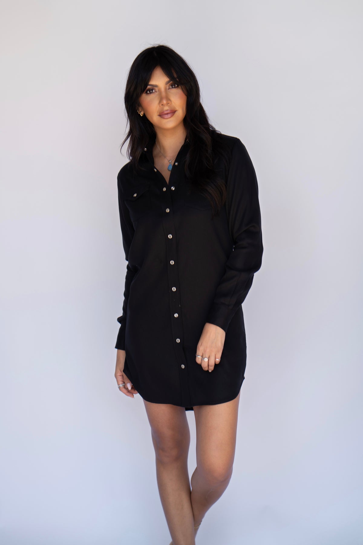 Model in the H Bar C Savannah women's black dress, a long sleeve Tencel western shirt dress with pearl snap placket and curved hem.