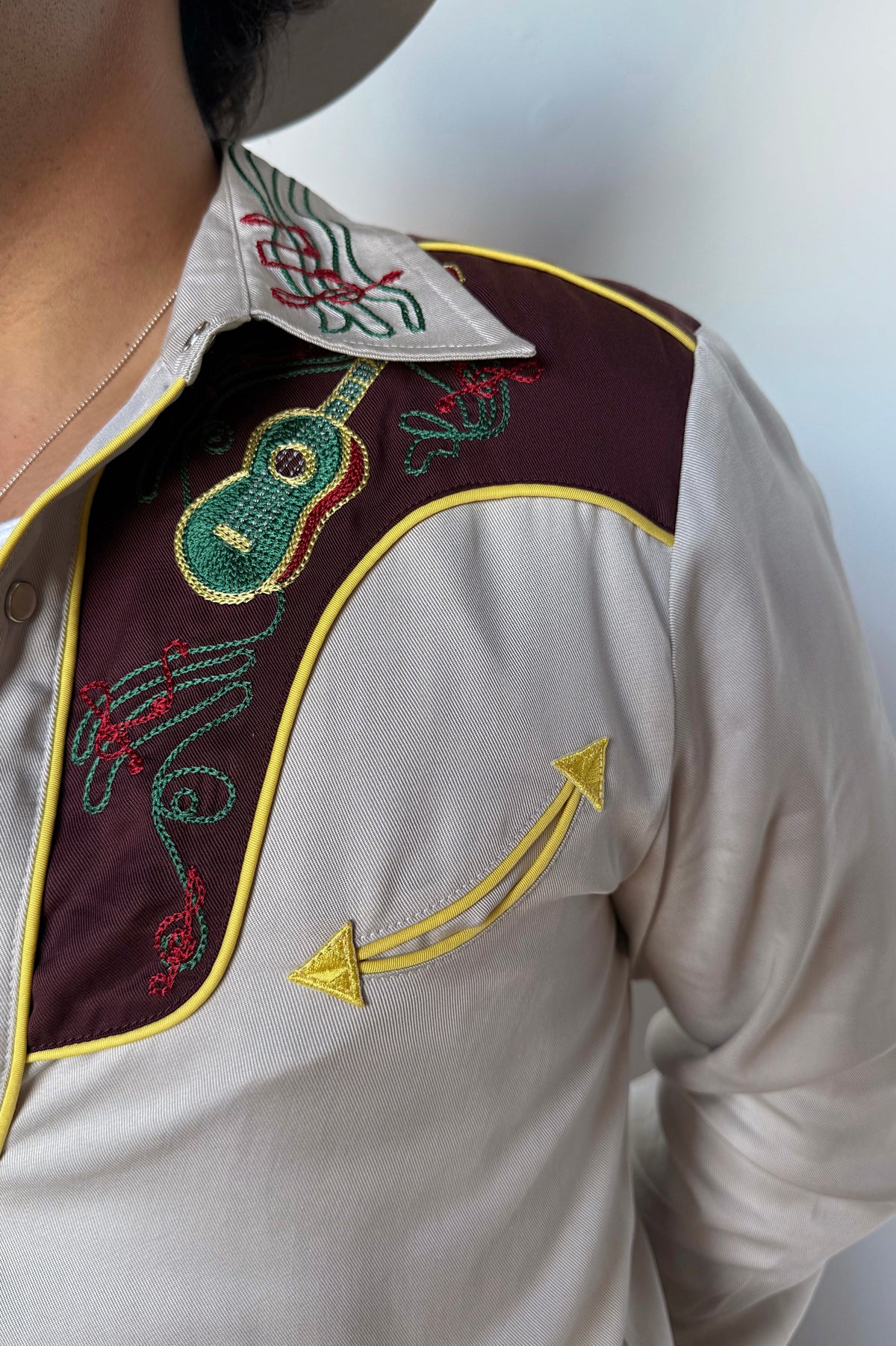 Close-up of the maroon yoke with green embroidery and yellow piping on the H Bar C Cowboy Bob shirt.