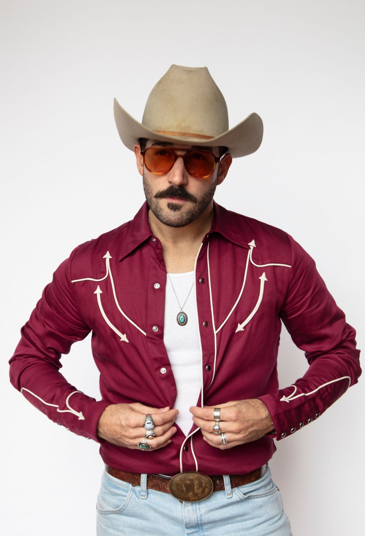 Front view of the H Bar C Reno maroon with off white western shirt with tinted glasses and cowboy hat.