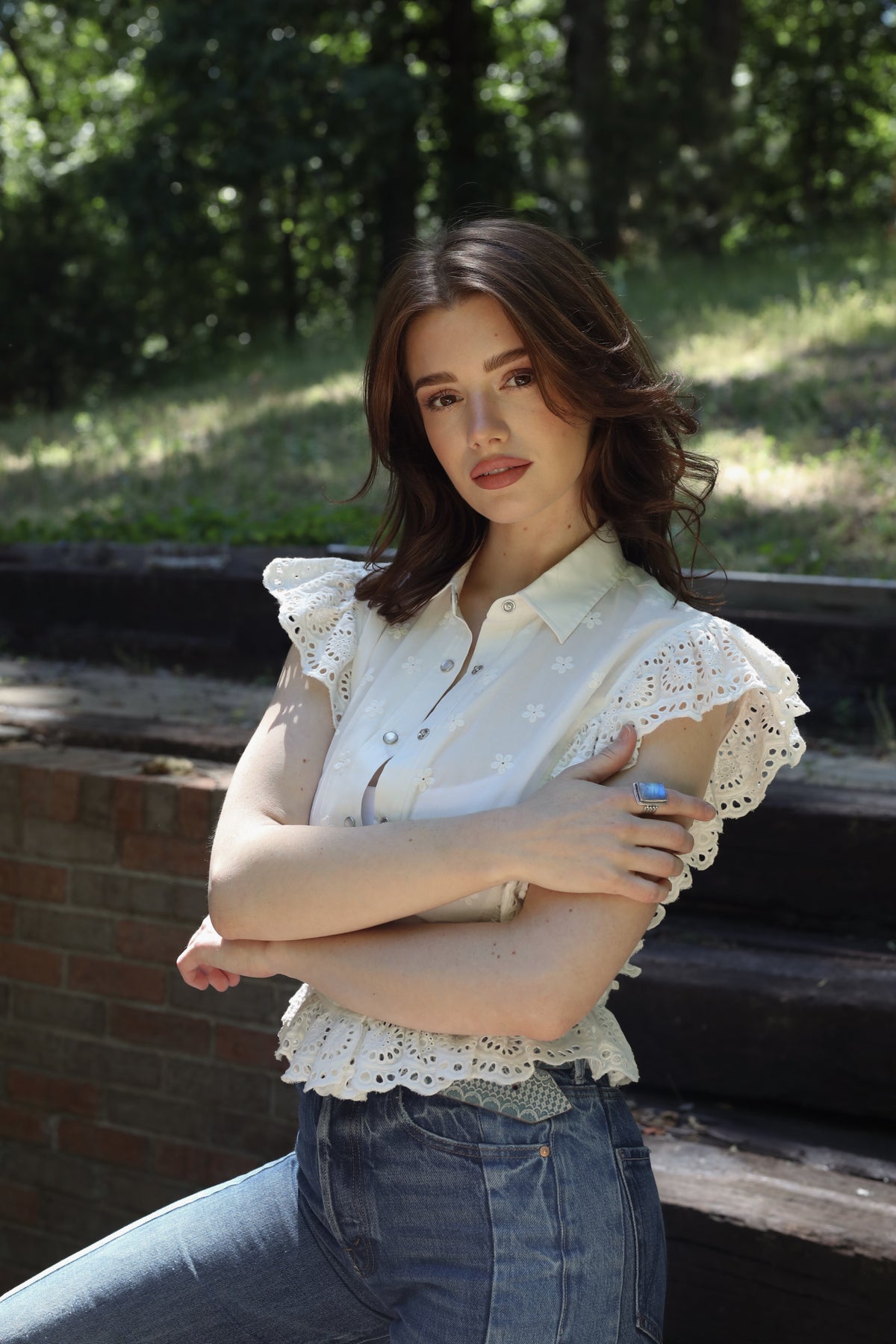 Woman outdoors wearing The Lexington by H Bar C, a white lace-trimmed western top, with jeans.