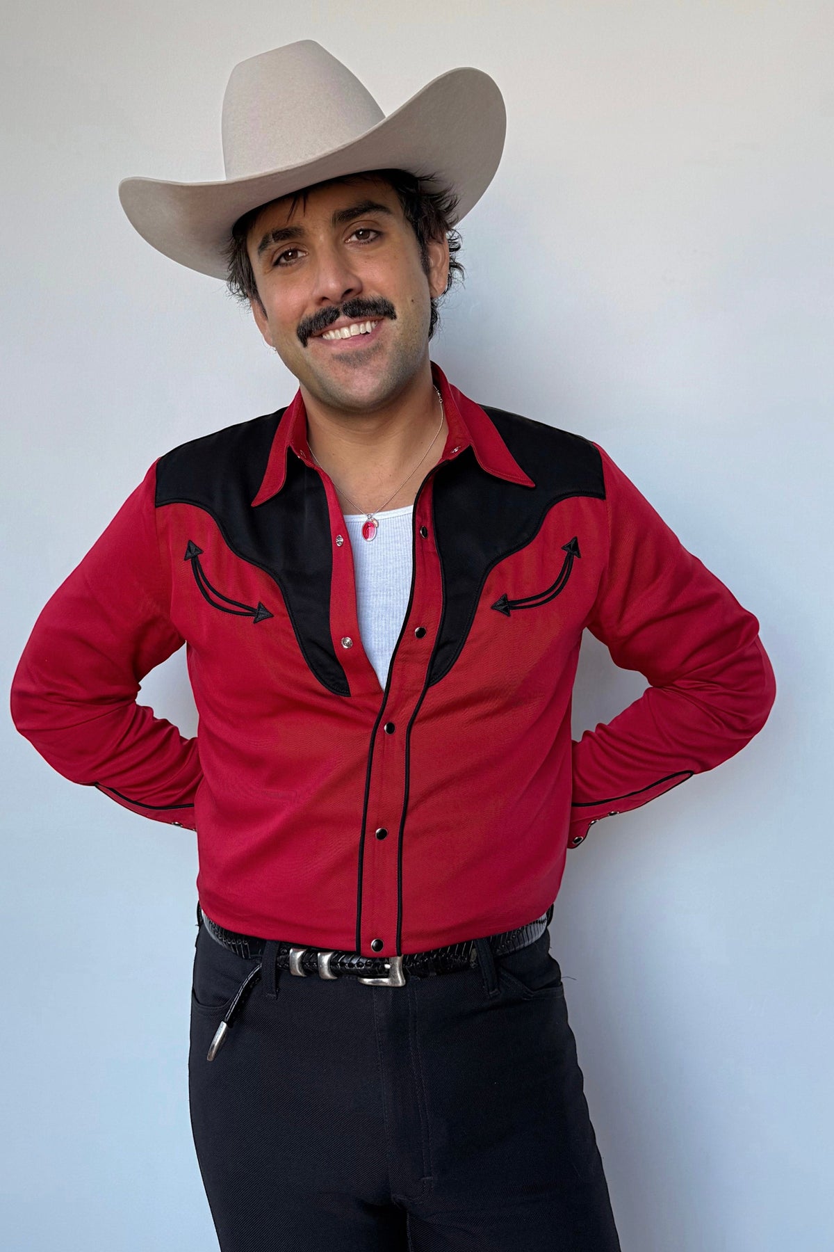 Man in a cream cowboy hat wearing the H Bar C San Juan men's shirt in red with black yokes and piping, a 1950s style western snap shirt.