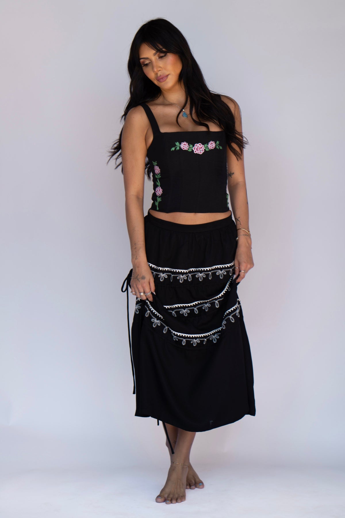 Woman wearing the H Bar C Canterbury black embroidered corset with a matching black western skirt.