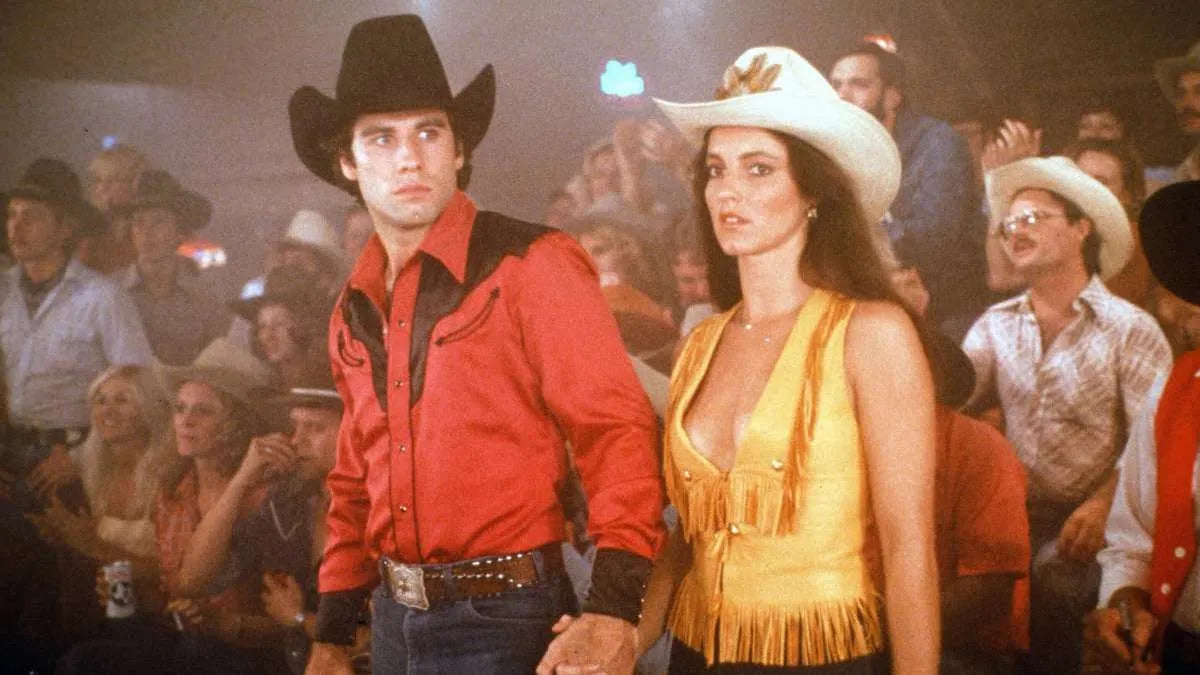 Vintage western film still of a cowboy in a red and black two-tone western shirt, the look that inspired the H Bar C San Juan red.