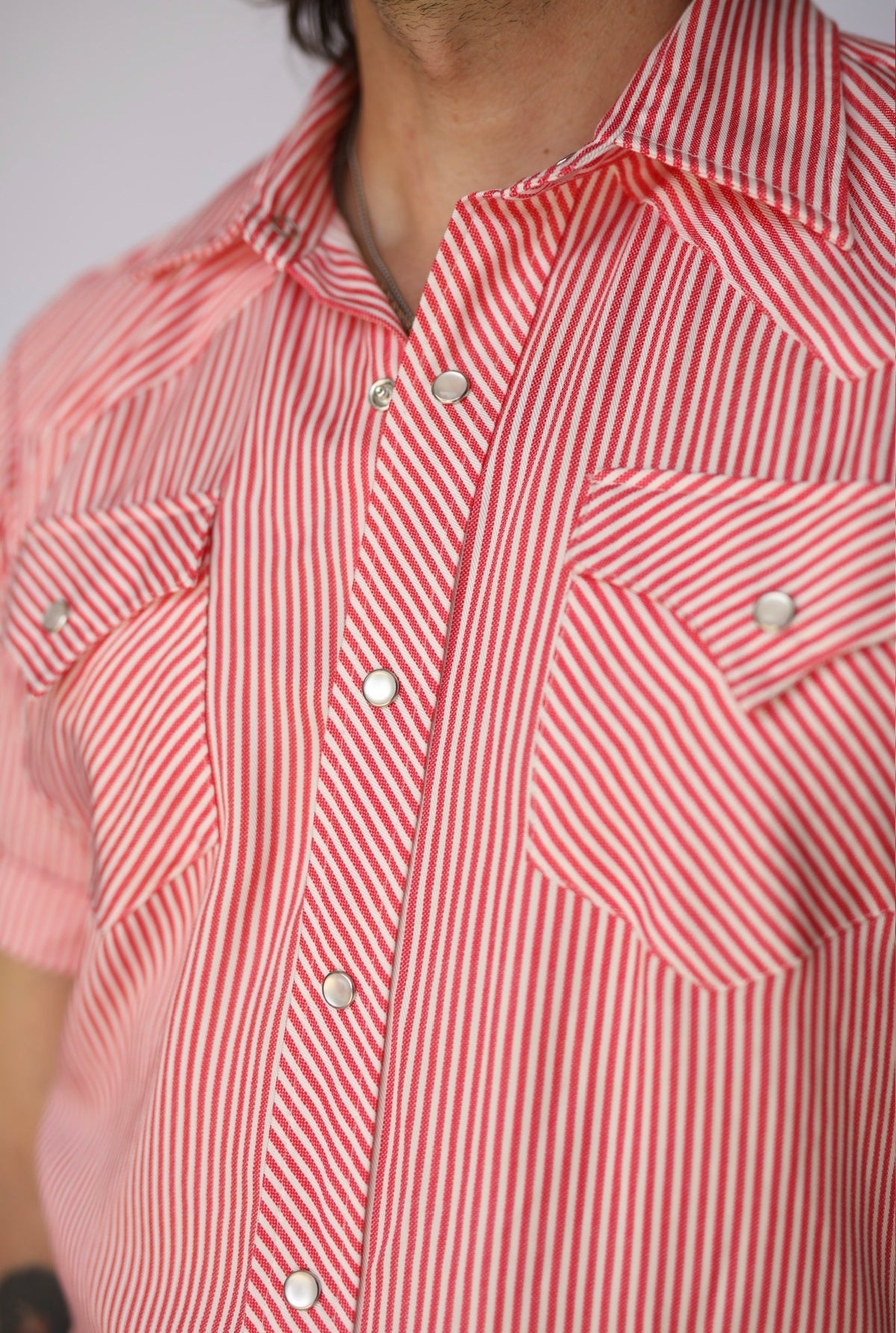 Detail of the chest pockets and pearl snaps on the H Bar C Newport red stripe western shirt.