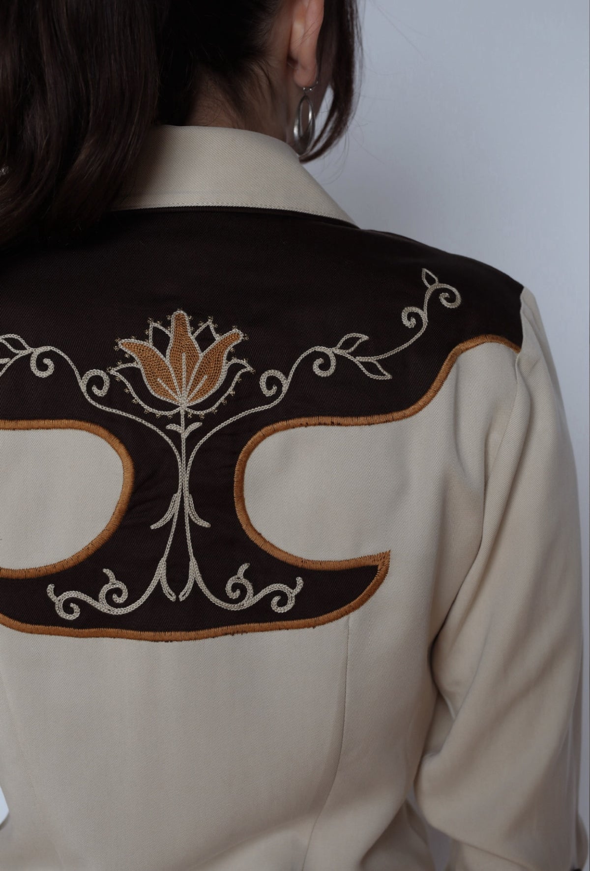 Back yoke detail of the H Bar C Santa Barbara women's shirt with embroidered tulip motif on brown.
