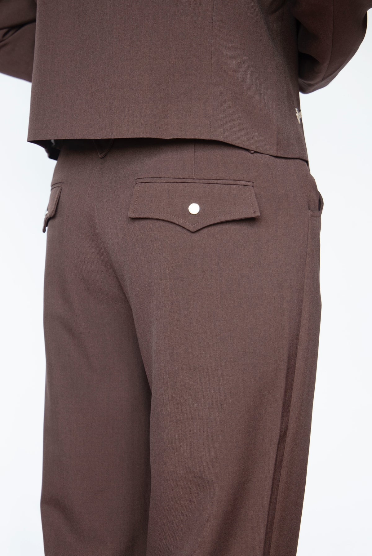 Back view of the H Bar C Franklin unisex western pants in chocolate brown worn with a matching jacket.