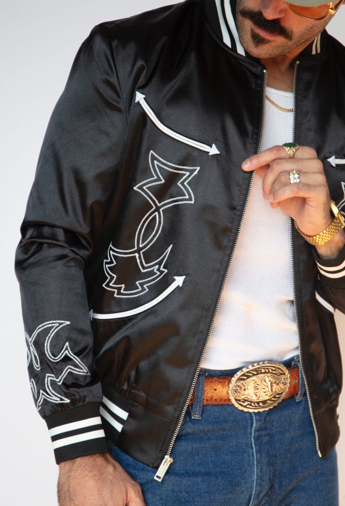 Close-up of the white arrow appliqué and chain stitch on the H Bar C Odessa black satin jacket.
