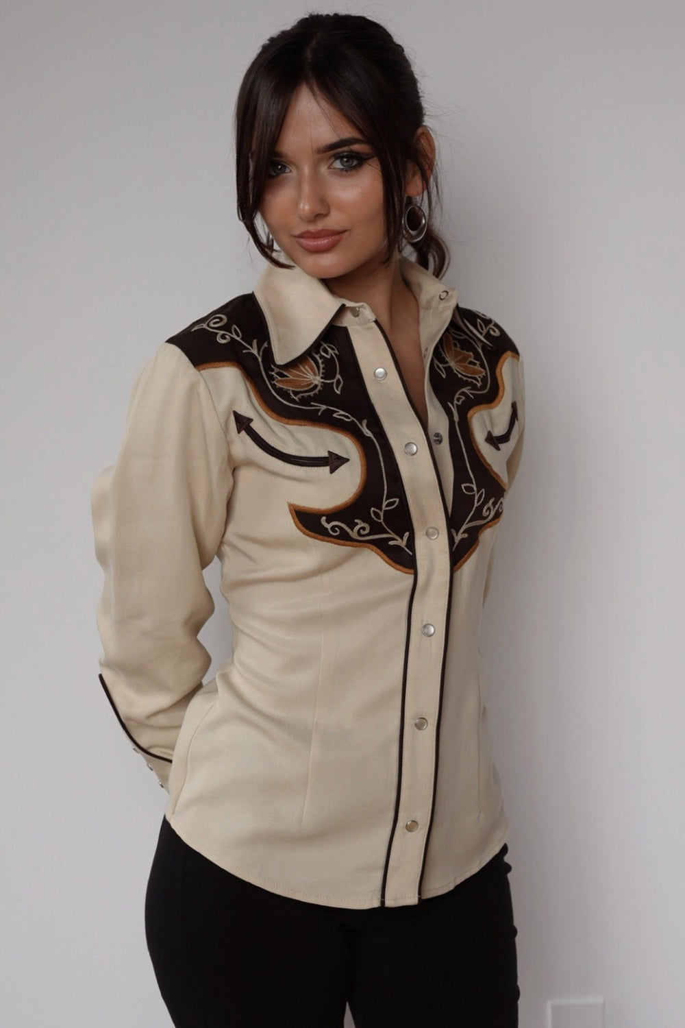 Front view of the H Bar C Santa Barbara women's beige and brown embroidered western shirt with black pants.