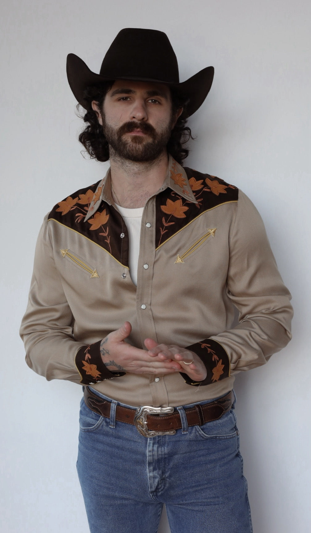 Front view of the H Bar C Stowe sandstone and brown embroidered western shirt with jeans.