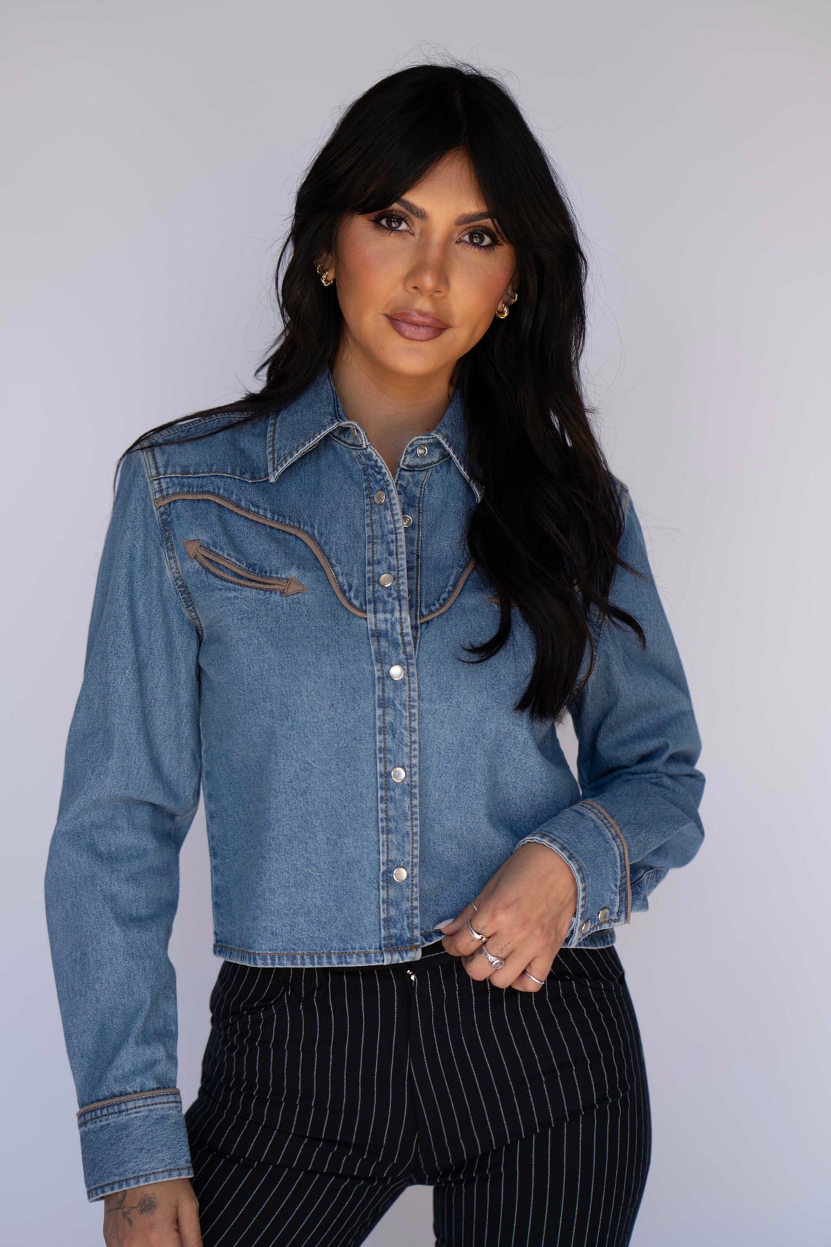 Front view of the Rustler x H Bar C cropped denim western shirt for women with pearl snaps and contrast piping.
