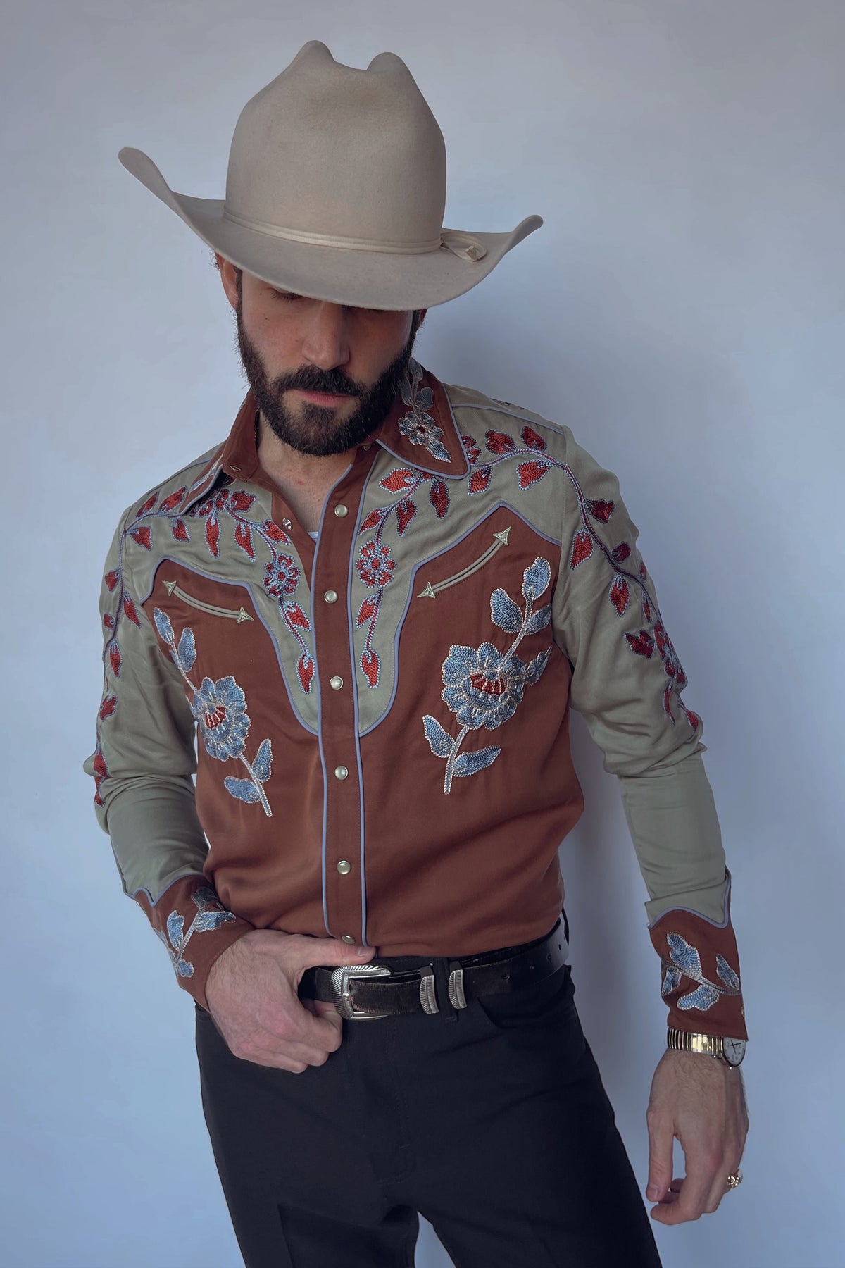 Man in a cowboy hat wearing the H Bar C San Antonio men's shirt in brown with sage green yokes and sleeves and red floral embroidery, a slim fit western shirt.