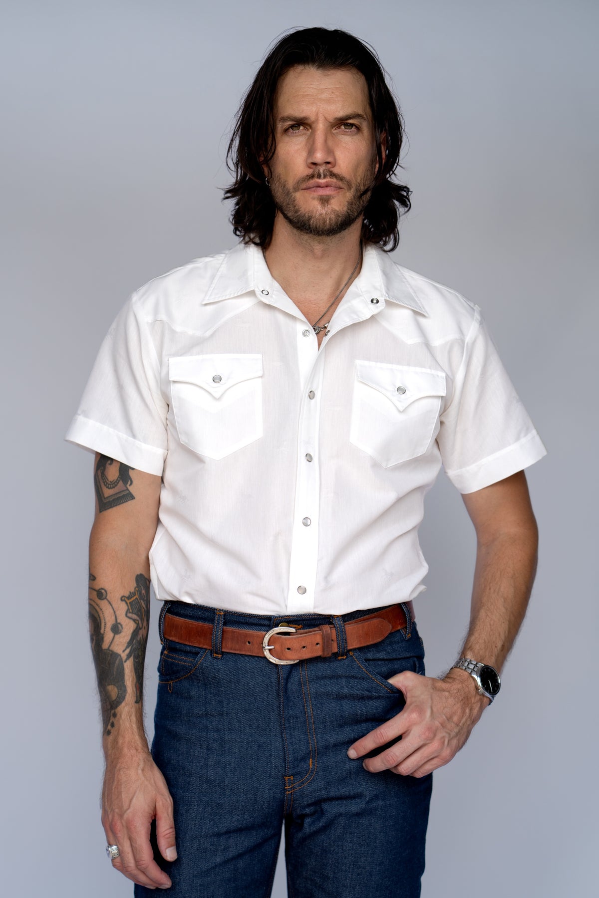 Front view of the H Bar C Newport Jacquard white short sleeve snap shirt with jeans.