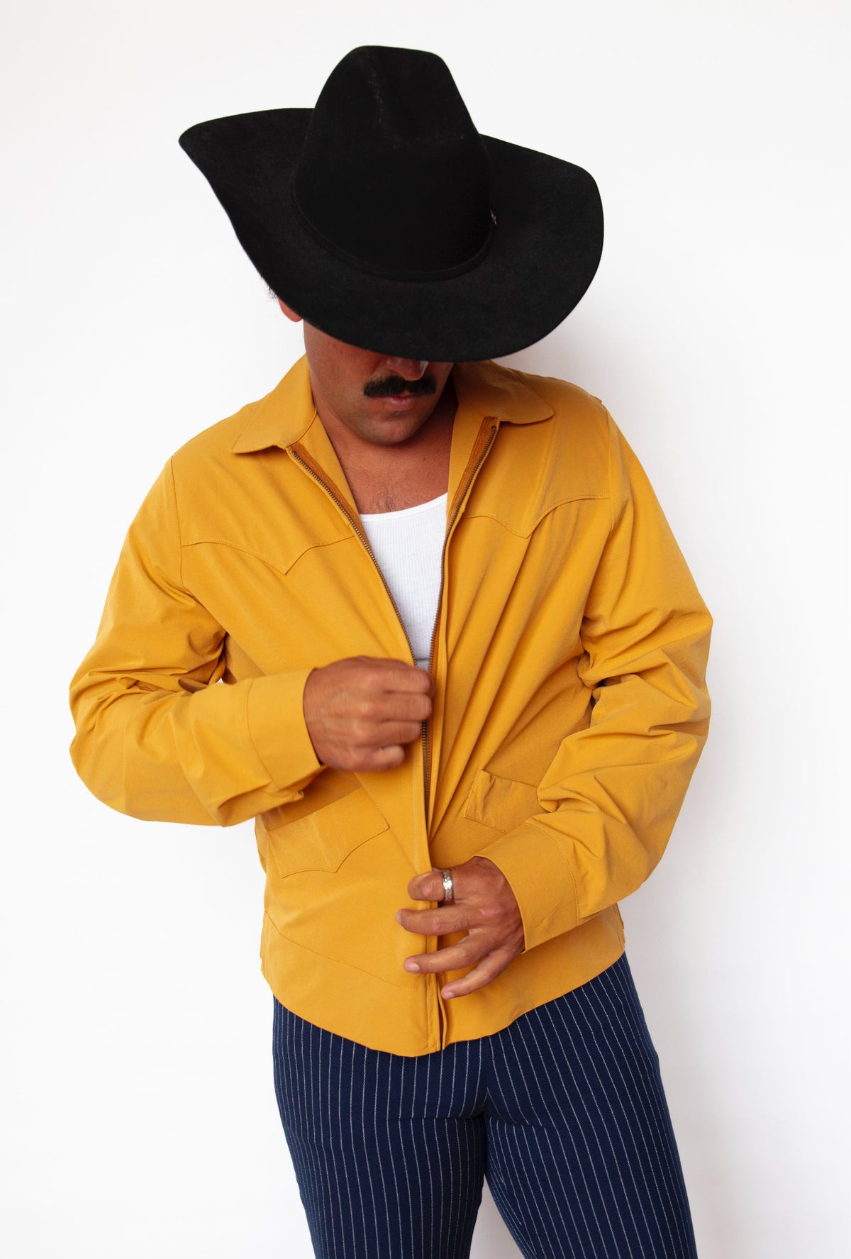 Man zipping the H Bar C Mustang mustard western jacket with a black cowboy hat.