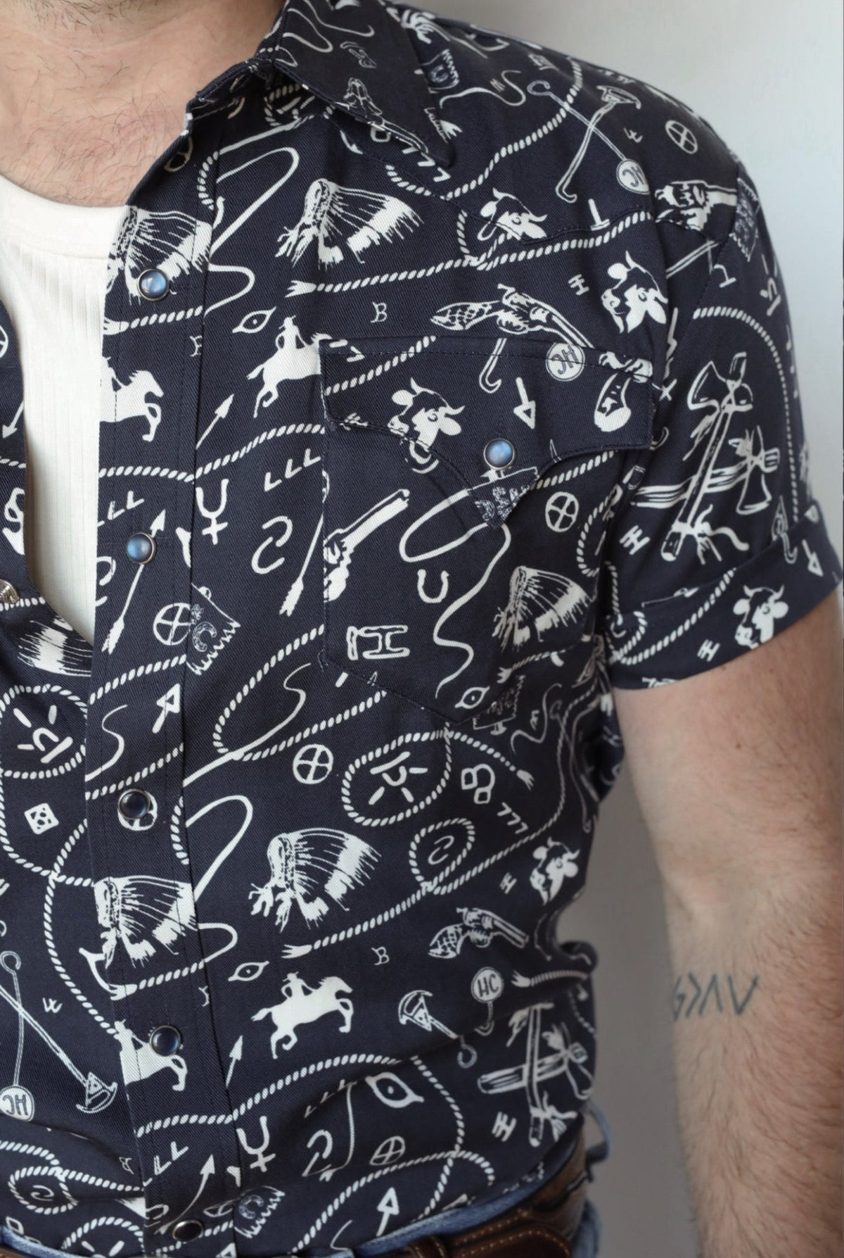 Close-up of the navy and white cowboy print and pearl snaps on the H Bar C Newport Rockridge shirt.