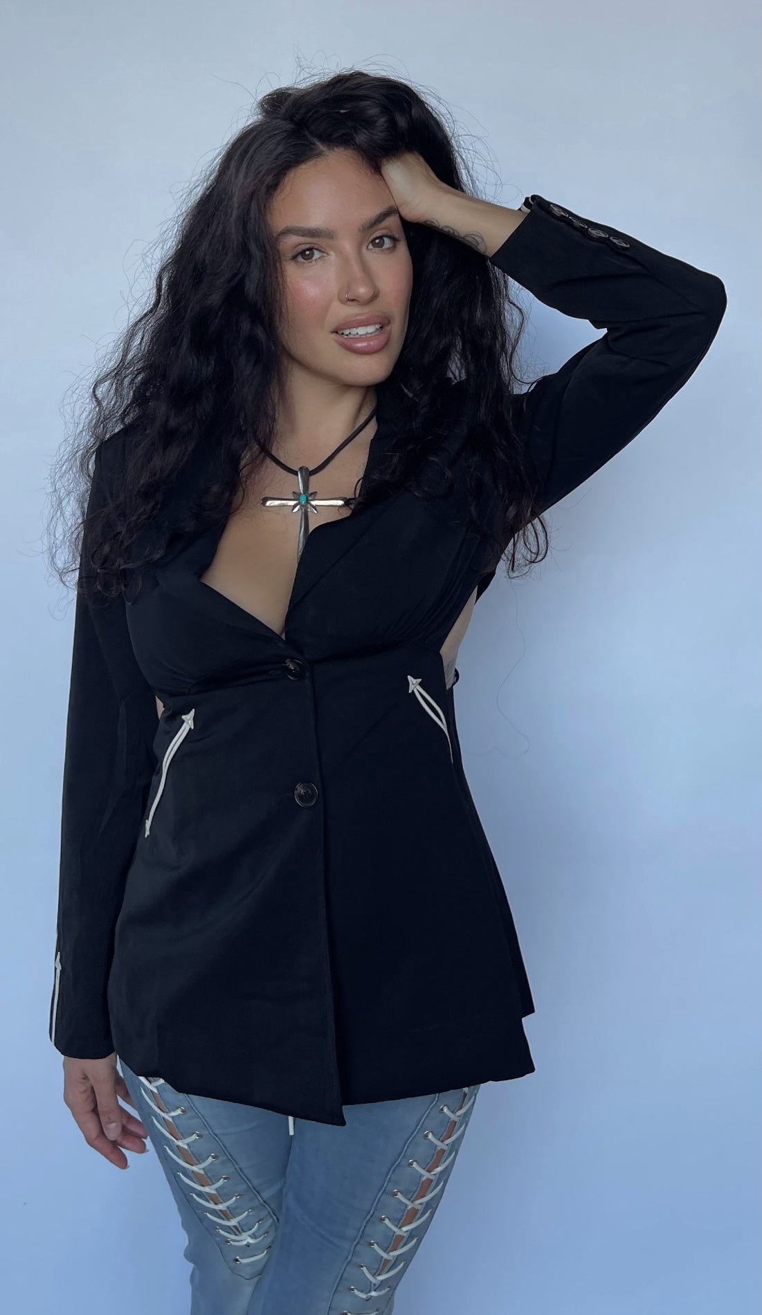 Model posing in the H Bar C Phoenix women's black jacket with white arrow details.