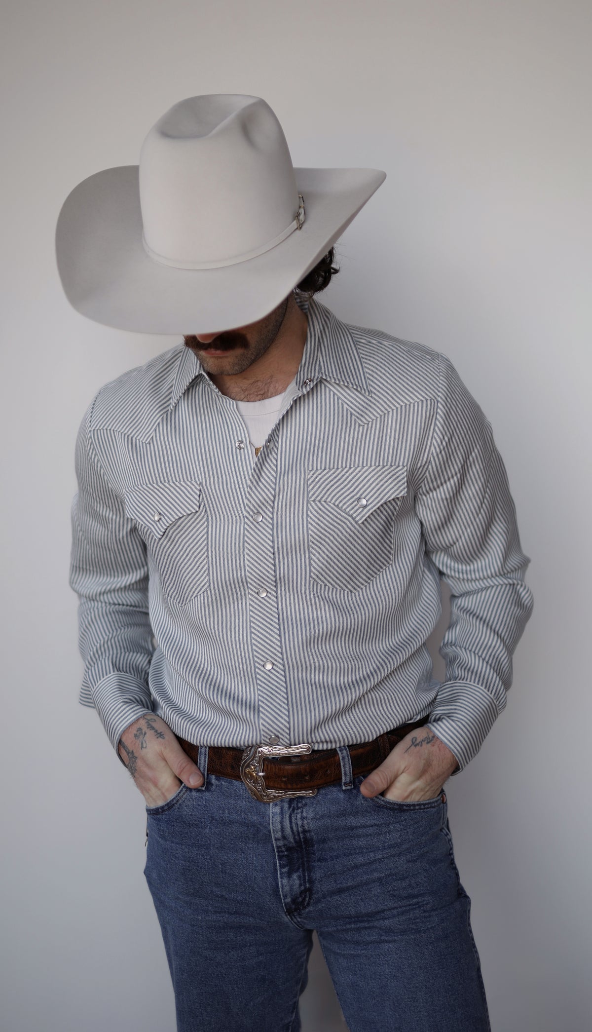 H Bar C Folsom long sleeve blue and white stripe snap shirt worn with jeans and a cream hat.