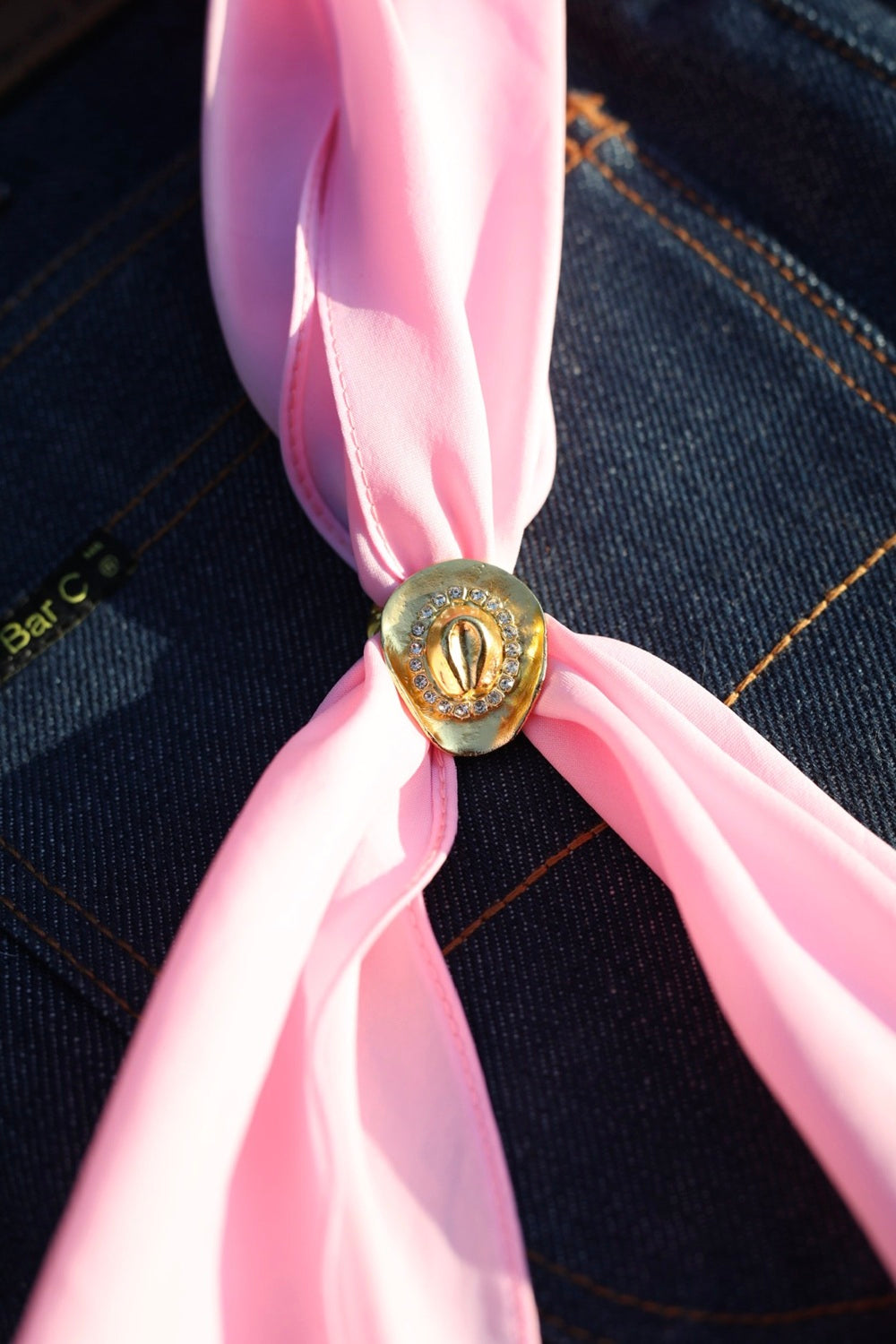 H Bar C rhinestone cowboy hat scarf slide in gold holding a pink silk wild rag, from Five Pieces of the Frontier.