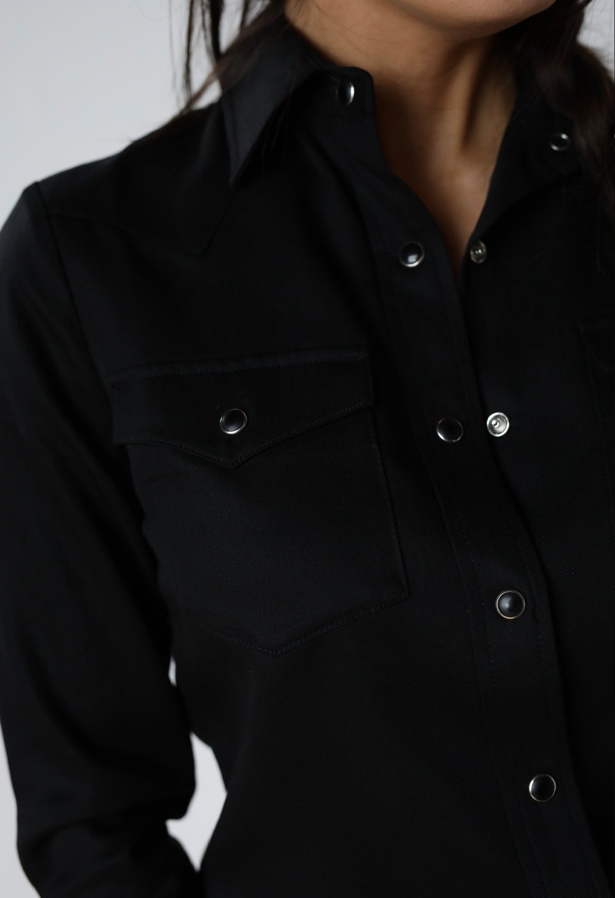 Close-up of the pocket flap and pearl snaps on the H Bar C Denver women's black shirt.